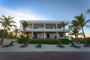 Private beachfront villa in Riviera Maya with palm trees, outdoor seating and direct access to the beach