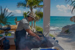 Private chef grilling food at an oceanfront property in Riviera Maya with the Caribbean Sea in the background