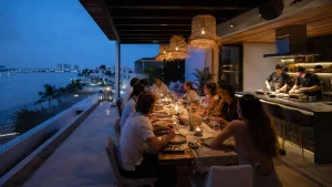 Private Chef in Cancun preparing dinner for a group of friends on a villa rooftop overlooking the lagoon at night.