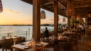 Open-air restaurant dining in Cancun with waterfront views at sunset