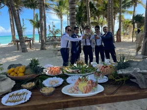 Riviera Maya Private Chef experience with guests enjoying drinks and fresh seafood at a beachfront celebration