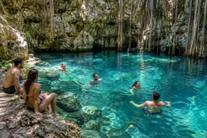 Cancun group activities with friends swimming together in a clear cenote during a day trip