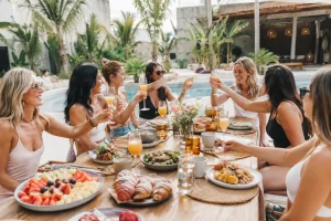 Poolside brunch at a Tulum villa with fresh fruit, pastries, breakfast dishes and drinks for a group of friends