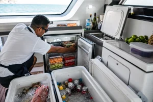Yacht catering team organizing chilled food, drinks and coolers before a charter from Puerto Aventuras